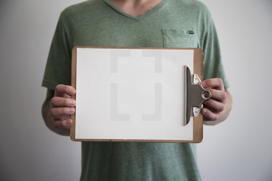 man holding a blank piece of paper on a clipboard