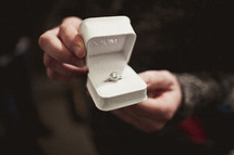 Man holding engagement ring in a box