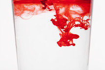 red flood coloring in water in a glass 