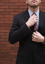a businessman adjusting his tie 