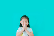 an Asian little girl praying 