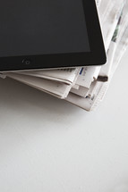 ipad on a stack of newspapers 