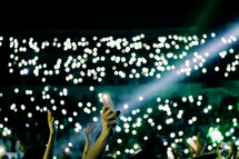 fans with raised hands at a concert 