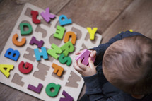 toddler with an alphabet puzzle 