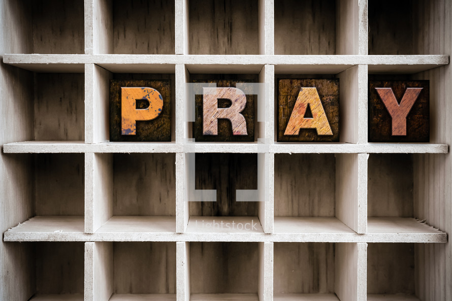 word Pray on a wood shelf 