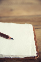 A pencil lying on blank white paper.