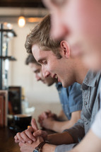 men's prayer group in prayer at a coffee shop 