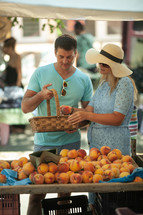 A couple getting peaches at the market