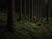 Man with headlamp sitting in dark forest