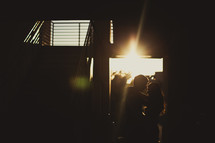 a couple standing in a doorway under the glow of a sunburst