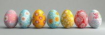 Row of colorful easter eggs on grey background.