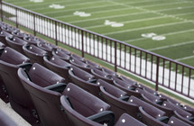 rows of stadium seats and football field 