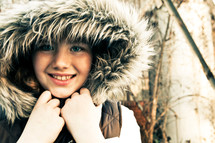 Young girl wearing a winter coat with furry hood