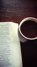 an open Bible and coffee mug