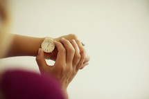 woman checking time on a watch.