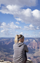 woman sitting at the top of a canyon
