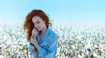 a woman standing in a cotton field 