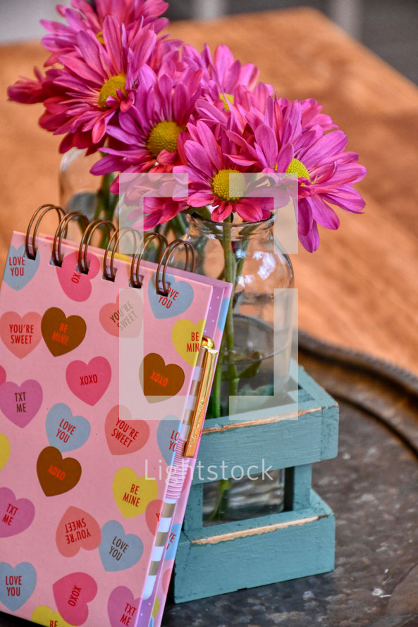 pink flowers in vases and valentine's day notebook 