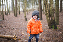 a child in a coat in a forest 