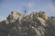 man at the top of a rock cliff 