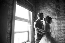 bride and groom dancing in a window 