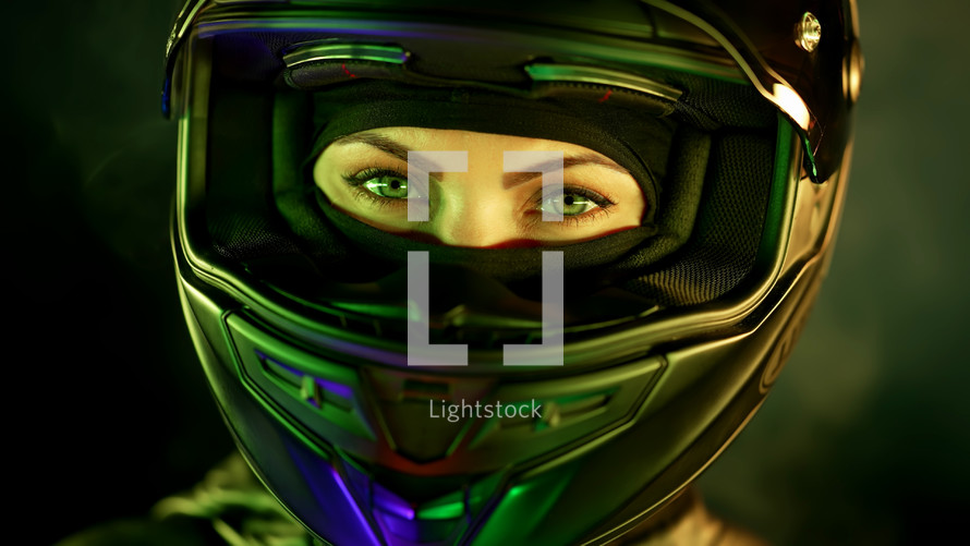 Young female motorcyclist woman in closed motorcycle helmet. Driver biker looking to camera under green colorful neon light with smoke or steam at night. Amazing aesthetic portrait. High quality photo