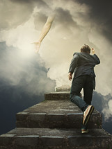 man climbing steps and reaching hand of God 