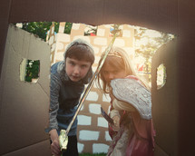 children playing a castle made of cardboard boxes 