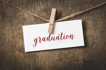 word graduation on white card stock hanging on a clothesline of twine