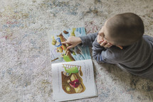 Little boy reading a picture book of the Bible story of Jonah.