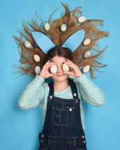 Little girl with Easter eggs in her hair 