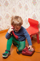 Young boy using red phone