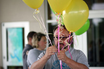 man holding helium balloons 