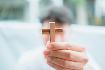 man holding a small wooden cross