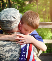a boy hugging his soldier father 