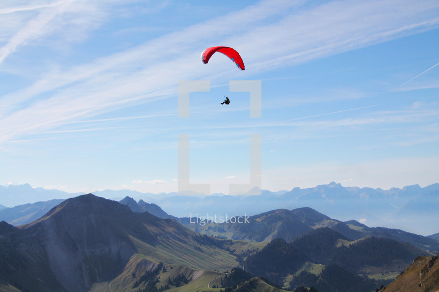man parachuting over a mountain 