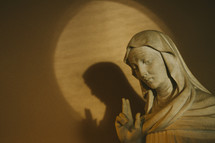 statue of Mary with two fingers raised to heaven