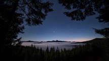 Blue nigh sky with stars in mountains forest with foggy clouds motion fast in evening nature landscape Time lapse
