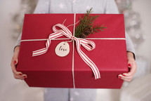 a woman holding a wrapped gift box