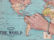 a woman pointing to Central America on a map 