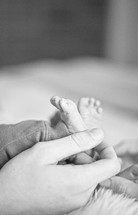 father holding a newborns tiny feet