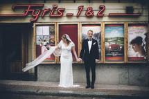 bride and groom in front of a vintage movie theater 