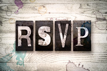 word RSVP on a white wash wood background 