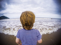 a child walking on a beach 