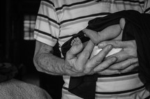a grandfather holding an infant grandchild 