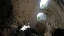 a man standing in a cave looking up 