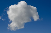 one large, fluffy, white cloud in a deep blue sky