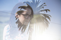 double exposure image of a palm tree and a woman 