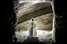 Jesus kneeling in prayer in a tomb