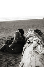 Happy couple sitting on beach sand tree marriage relationship love
